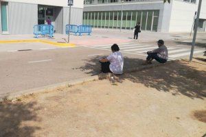 Gente esperando en el párking del hospital a los pacientes que acompañan