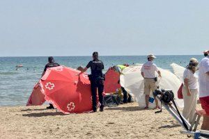 Moment en el qual els serveis funeraris retiren el cadàver de la dona a la platja de Gandia