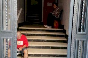 Madre e hijo en el portal del edificio de Gandia tras ser desahuciados