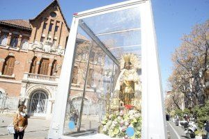 La imagen peregrina de la Virgen recibe los aplausos y pétalos de flor de vendedores del Mercado Central y de Ruzafa