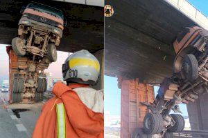 Un camión queda en posición vertical y bloqueado bajo un puente en Mislata