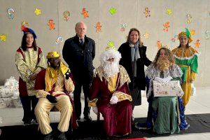 Camarero asiste a la llegada de los Reyes Magos a la escuela infantil de Casa Caridad en Benicalap para participar en el reparto de regalos