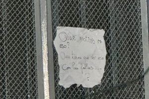 Cartel bajo los ninots de los migrantes