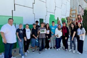 Alumnado del IES Joan Fuster de Sueca realiza un mural decorativo en una de las paredes del puente ubicado en la calle Cronista Burguera
