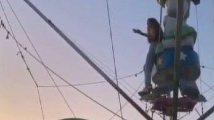 Una jove es cola en la fira d'Alcossebre durant la matinada i puja a una atracció